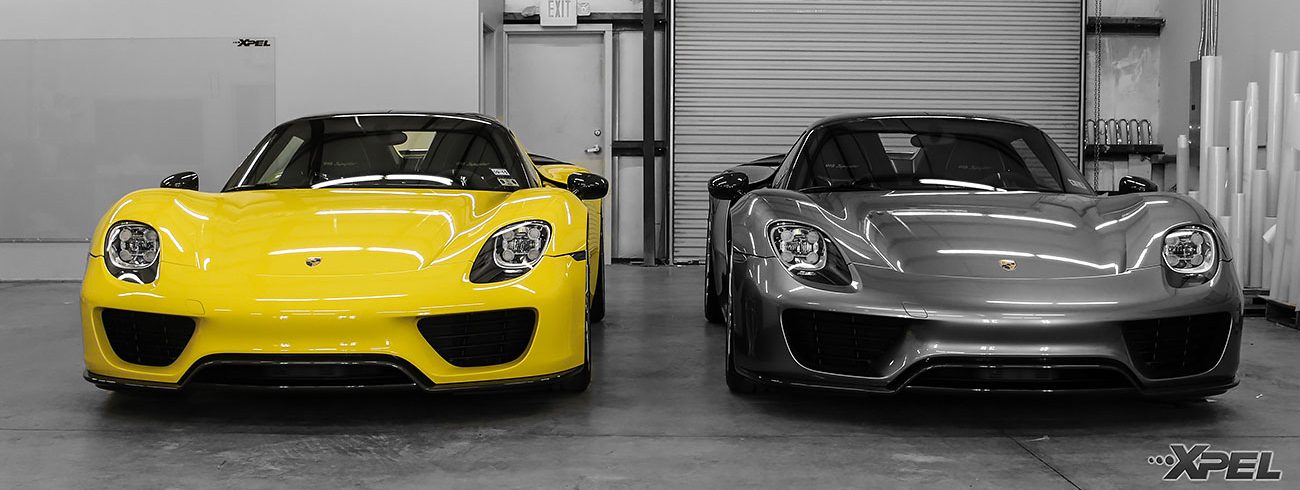yellow and gray sports car parked next to each other in the shop bays